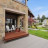 Pixelated static image of a house exterior with stone facade, dark doorway, and green lawn under blue sky.