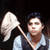 A person holding a large white feather duster against a black background with overlaid text.