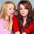 Two women in red dresses stand side-by-side with one woman's hand near the other's face, set against a light background.