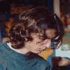 nine static images showing a person with long dark hair in various poses and clothing, including maroon, blue, white, green, red, and pink garments