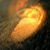 Animated orange flame-like shape on left transitions to circular silver emblem with pink and yellow striped center on right.