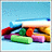Pixelated static image of a colorful, abstract vehicle-like shape against light blue background with scattered darker pixels.