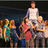 Group of stylized figures in various poses with distinct clothing colors against a dark background.