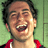 Pixelated static image of a person laughing with mouth open, wearing red clothing against green background.
