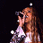 A 48x48 pixel animated buddy icon featuring a woman singing into a microphone on the left and green text reading "Original Icons .com" on the right, displayed as a contact sheet with two frames.
