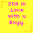 Yellow background with pink text reading 'Still in Love with u Boyy.' and orange star decorations.