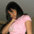 A pixelated image of a person with long dark hair wearing a light pink sleeveless top against a muted gray background.