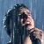 Two side-by-side animated frames of a person with dark hair singing into a microphone against contrasting backgrounds.