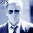 Static 48x48 pixel icon of a person in formal attire with white hair, dark sunglasses, and a bow tie against a light blue background.