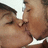 Two figures in close physical proximity with eyes closed, sharing a kiss; one figure has dark hair and the other light brown skin tone.