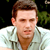 Static pixelated image of a person in a light-colored shirt against dark background with green foliage.