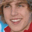 Pixelated image of a smiling person with light brown hair wearing red clothing, next to blue background with cyan text reading "cody lindsey is sooo cute he is hot i luv him".