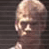 Pixelated static image of a bald character with closed eyes and a neutral expression against dark horizontal stripes, likely from Star Wars media.