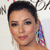 A pixelated close-up of a person with dark hair pulled back, wearing a colorful beaded earring and a thin black choker necklace.