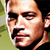 Pixelated close-up of a person's face with visible facial features and partial background elements.