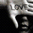 Pixelated grayscale image of a stylized character with large eyes and an open mouth, partially obscured by text reading 'LOVE' on the right side.