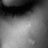 Black-and-white close-up of a person's eye with eyelashes, next to red pixelated text on black background.