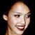 Pixelated close-up of a person's head and upper neck against a dark background, showing a bald scalp, ear, and partial facial features.