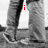 Black-and-white image of a person's lower body in jeans standing on a textured surface with red text overlays changing across frames.