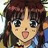 Anime-style character with brown hair and bangs, wide eyes, and a slightly open mouth showing a pink tongue, wearing a blue garment with a yellow collar.