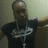 A pixelated figure in a dark shirt with light text on chest, standing against muted background.