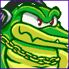 Pixel art of a green crocodile-like creature with red eyes, yellow underbelly, and gold chain around neck against gray background.