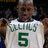 Pixelated image of a person wearing a white sports jersey with green text and number, set against a dark background.