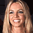 Pixelated image of a smiling person with long blonde hair, accompanied by pink pixelated text on black background.
