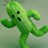Green pixelated character with four black circular eyes, outstretched arms, and a long vertical body against a muted gray-green background.