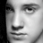 Black-and-white pixelated close-up of a human face showing eyes, nose, and mouth with visible grayscale shading.