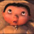 Pixelated cartoon-style face with wide eyes, open mouth, and dark hair against a brown background.