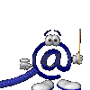 Animated blue @ symbol character with white eyes, hands holding a pointer stick and small object, standing on two rounded feet against gray background.