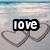 Beach scene with two heart outlines drawn in sand, overlaid text "love" shifts position across frames.