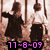 Two figures in dark clothing stand against a light background with vertical lines; pink text reads "11-8-09" at the bottom.