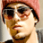 Pixelated static image of a person wearing sunglasses and a pink cap, cropped to show upper face and shoulders against a neutral background.