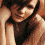 A pixelated image of a person with dark hair, showing three sequential facial expressions from left to right: smiling while touching the head, squinting eyes, and neutral expression.