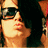 Pixelated image of a person with dark hair and sunglasses on the left, next to pixelated text reading 'kisses!' on white background.