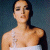 A pixelated image of a person with dark hair in an updo wearing a white strapless garment against a gradient background, next to green text reading "Original Icons .com" on a solid green field.