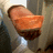 A pixelated orange-brown object resembling a curved slice of food on a dark base with light reflections.