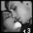 Black-and-white pixelated image of a person with closed eyes and a hand near their face, showing a small white circular object below.