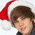 Pixelated image of a person wearing a red and white Santa hat with brown hair, light skin tone, and dark clothing against a plain background.
