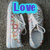 A pair of white sneakers with colorful text on the sides, displayed in a with text overlays changing from 'Love' to 'them!' across frames
