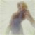 Pixelated figure with light hair in a dark sleeveless top against a pale background, arms extended in a dynamic pose.