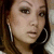 A woman with long brown hair and large silver hoop earrings appears in three distinct poses with subtle facial expression changes.