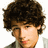 Pixelated close-up of a person with dark curly hair, light skin tone, and visible facial features including eyes, nose, mouth, and ear.