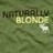 Pixelated green background with dark and light text reading 'NATURALLY BLONDE' in blocky letters, a white cursor icon to the right of 'BLONDE'.