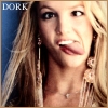 A close-up of a person with long blonde hair wearing large dangling earrings and a necklace, with the word 'DORK' in white text on a blue background in the top-left corner.