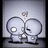 Pixelated image of two large circular heads with small bodies, one head has a white eye and the other a black eye, both facing each other against a gray background.