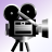 Pixelated black-and-white camera icon on tripod with dual reels, mounted lens, and rectangular body against light purple gradient background.