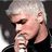 Pixelated image of a person with short light hair holding a microphone, surrounded by red text and heart symbols on a black background.